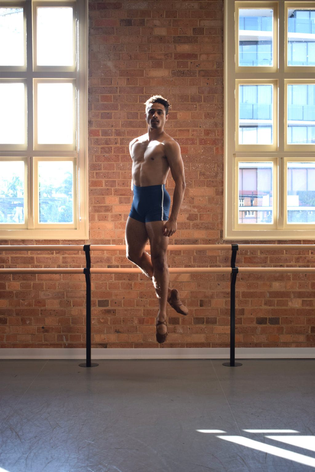 Male dancer, Patricio Reve wearing Gents 1/4 GT 1.0 short tights in Atlantis Blue with white piping – mid-thigh performance compression shorts