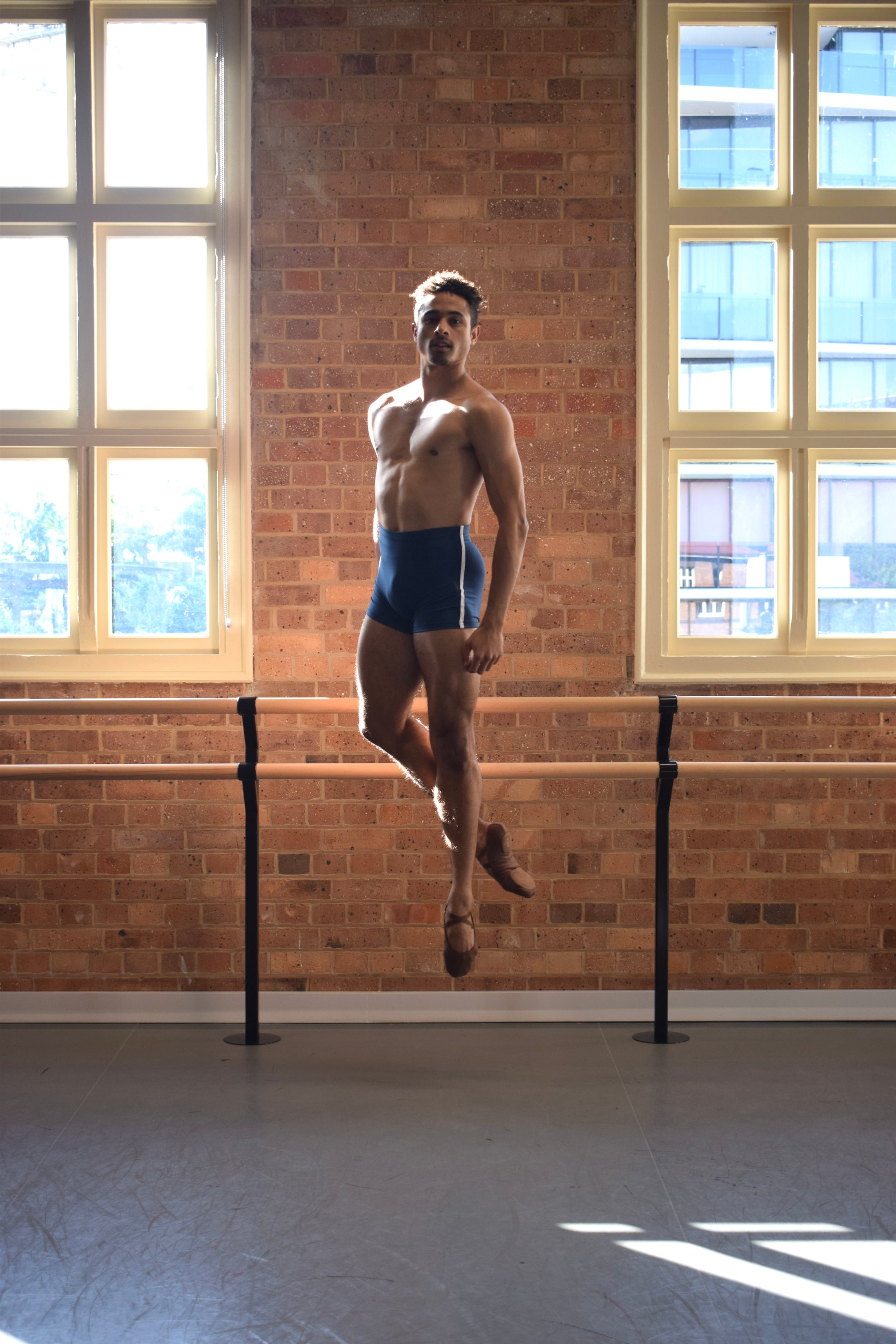 Male dancer, Patricio Reve wearing Gents 1/4 GT 1.0 short tights in Atlantis Blue with white piping – mid-thigh performance compression shorts