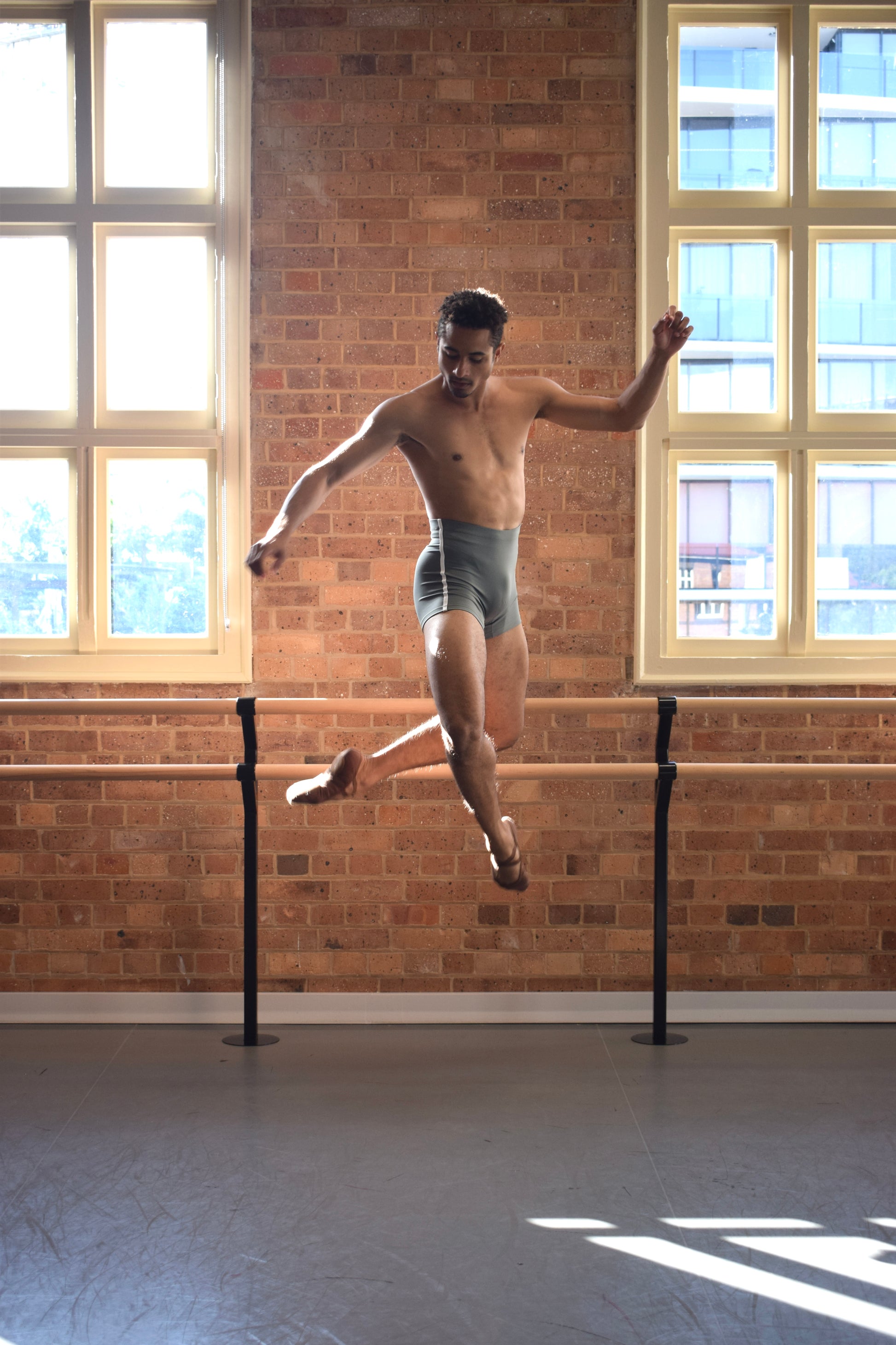 Male dancer, Patricio Reve wearing Gents 1/4 GT 1.0 short tights in Moss Green with white piping – mid-thigh performance compression shorts