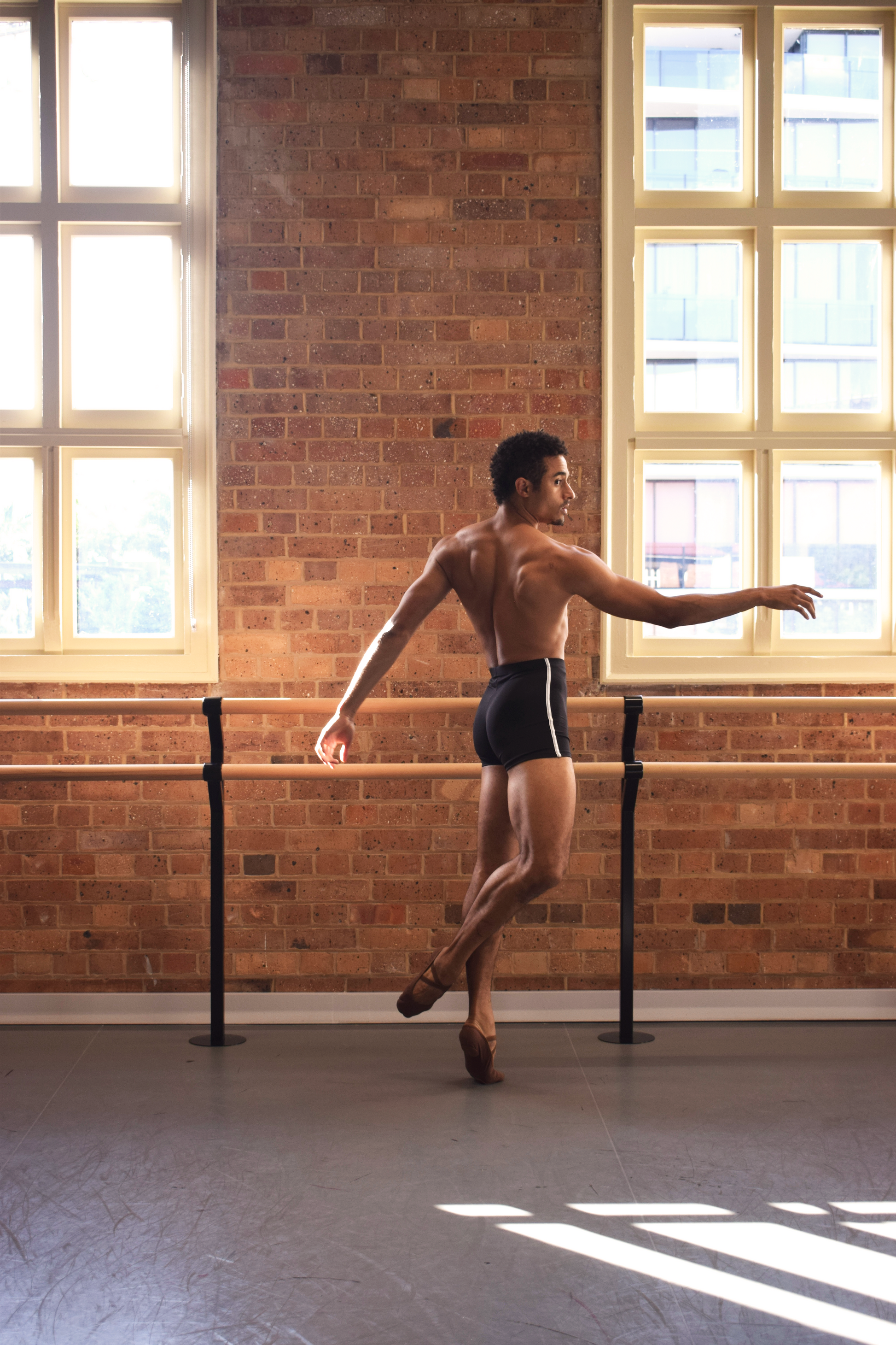Male dancer, Patricio Reve wearing Gents 1/4 GT 1.0 short tights in black with white piping – mid-thigh performance compression shorts
