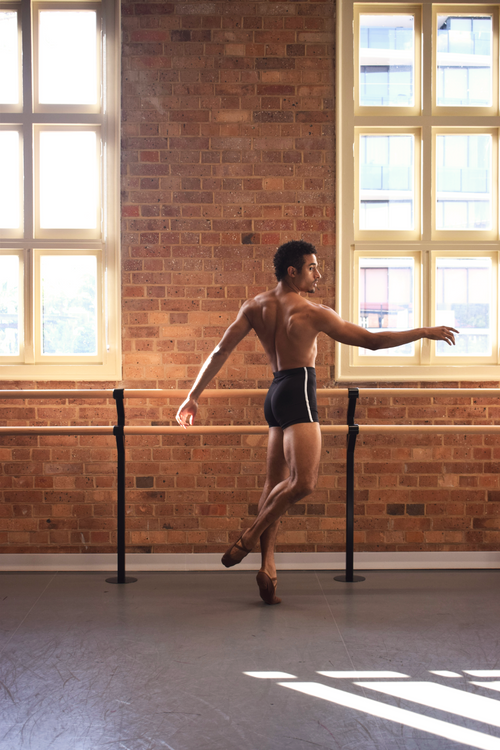 Male dancer, Patricio Reve wearing Gents 1/4 GT 1.0 short tights in black with white piping – mid-thigh performance compression shorts